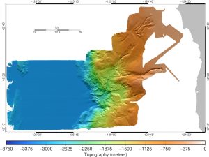A map shows the bathymetry of the Rogue Canyon. On the right is the Oregon coast in gray. The multicolored bathymetry map illustrates depth with a gradient of colors from orange to yellow to green to blue. The Rogue Canyon system extends from the top right of the map to the bottom center. To the left of the canyon is a black-and-white scale bar that reads km with markers for 0, 12.5, and 25 kilometers. Around the map are latitude and longitude data. Underneath the map is a key labeled Topography (meters), with a depth color gradient that includes, from right to left, white, orange, yellow, green, turquoise, blue, and purple, with a notched bar representing depth. The notches on the bar appear in increments of 375 meters from 0 on the right to -3750 on the left.